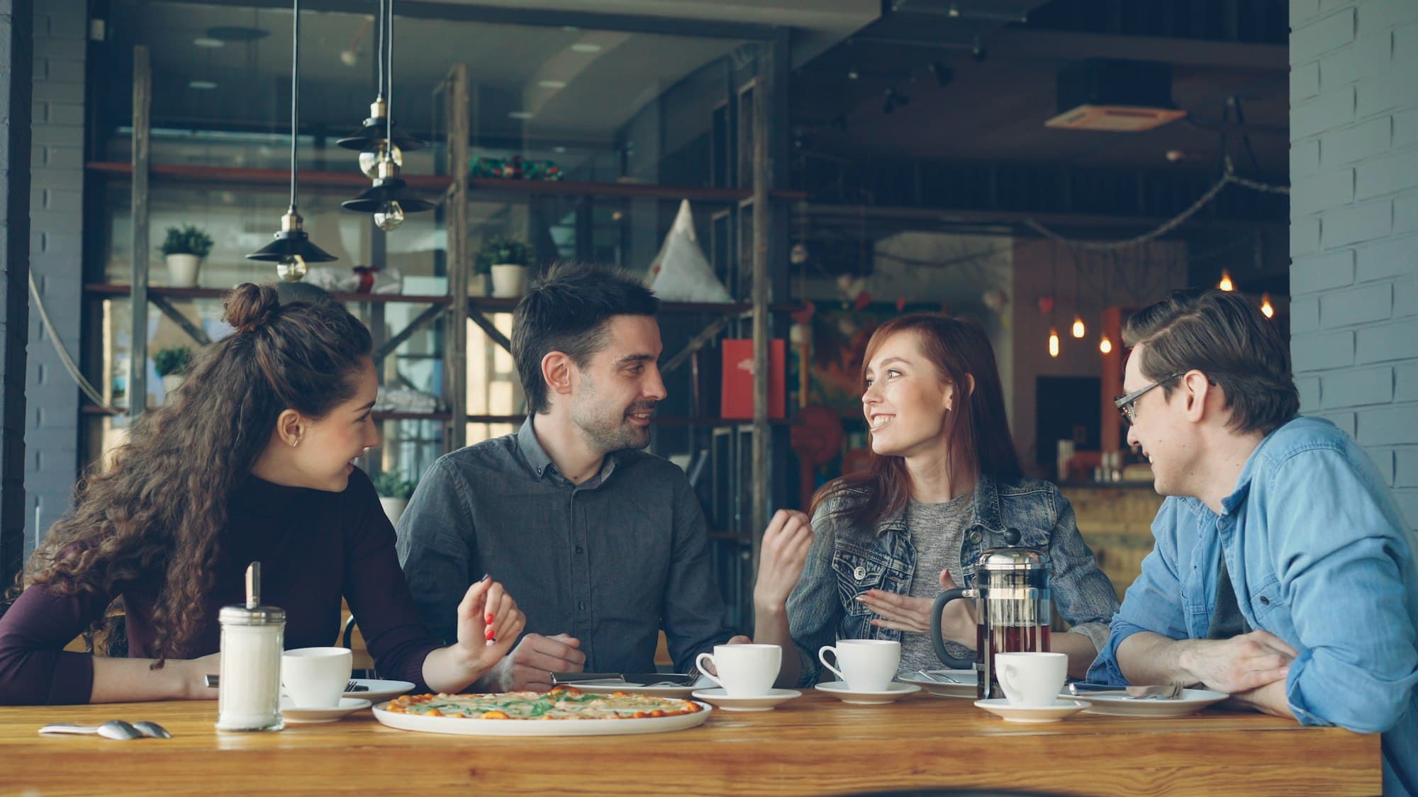 A group of friends talking over coffee at a cafe